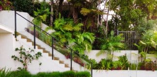 a white house with a green lawn and stairs